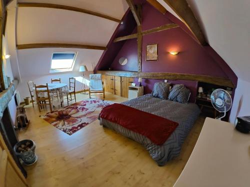 a bedroom with a large bed and a dining room at La Source in Sermaise