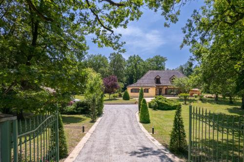 une allée menant à une maison avec une clôture dans l'établissement Maison Saint-Blaise Rampieux, à Rampieux