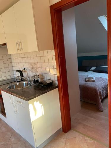 a kitchen with a sink and a room with a bed at apartment IVA in Supetarska Draga