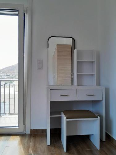 a white dressing table with a mirror and a window at Preet House in Víssa