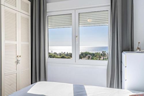 a bedroom with a window with a view of the ocean at Espectacular Dubamar 606 in Aguadulce