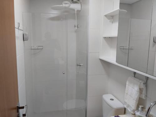 a bathroom with a glass shower with a toilet at Barra Pinauna Studio in Salvador