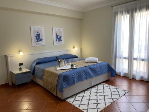 um quarto com uma cama grande e um cobertor azul em Scala dei Turchi Palace Suites em Realmonte