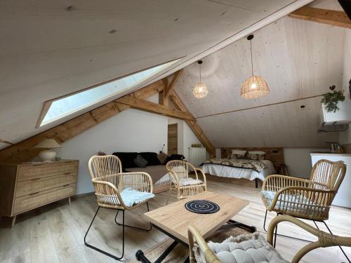 ein Wohnzimmer mit Korbstühlen und einem Tisch in der Unterkunft CHAMBRES D'HÔTES LES CHAMBRES D'ELSA in Albiez-Montrond