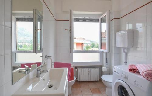 uma casa de banho com um lavatório e uma máquina de lavar roupa em Cozy Apartment In Sal With Lake View em Salò