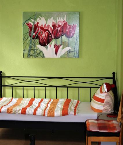 a bedroom with a painting of red and white flowers at Herrenhof 12 in Worms