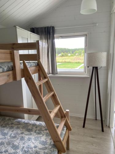 a bunk bed in a room with a window at BIAŁE DOMKI in Rusinowo