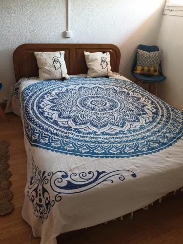 - un lit avec une couette bleue et blanche dans l'établissement T2 plage place parking wifi gratuit, à Port-la-Nouvelle