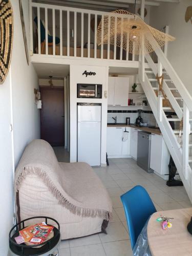un salon avec un escalier et une cuisine dans l'établissement T2 plage place parking wifi gratuit, à Port-la-Nouvelle