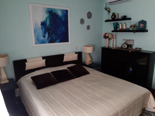 a bedroom with a bed with a blue painting on the wall at RobAp in Palanga
