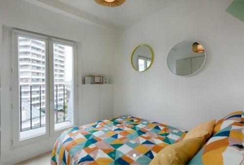 um quarto com uma cama e uma janela em Charmant 2 pièces calme et cosy em Paris