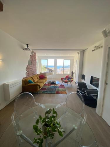 a living room with a glass table and a couch at La Flibuste des Goudes, maison avec jardins aménagés vue et proche mer au coeur du Parc National du Massif des Calanques in Marseille