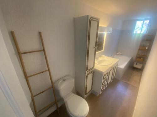 a white bathroom with a toilet and a sink at Parc National des Calanques, LA FLIBUSTE DES GOUDES Maison 2 chambres CLIMATISEE, jardins Jaccuzzi proche plage large vue mer PARKING reserve a l arrivee in Marseille