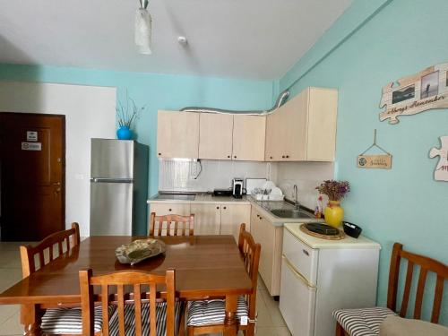a kitchen with a wooden table and a table and chairs at Saranda Aquamarine Sea View Condo in Sarandë