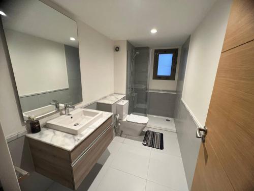 a bathroom with a sink and a toilet and a mirror at MKD Marina Residence in El Alamein