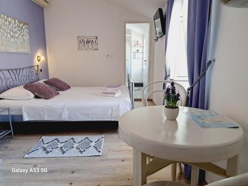 um pequeno quarto com uma mesa e uma cama e uma mesa e cadeira em Heritage Rooms Kut em Vis