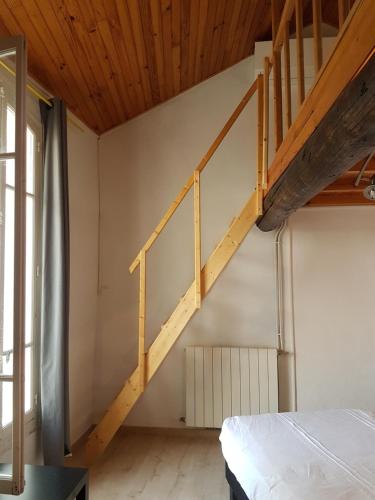 ein Schlafzimmer mit einer Holztreppe in einem Haus in der Unterkunft Chambre mezzanine in Vacqueyras