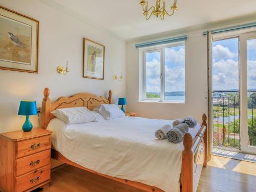 a bedroom with a bed with a view of the ocean at 7 Roundham Heights in Paignton