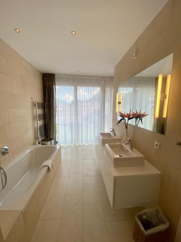 a bathroom with two sinks and a tub and a mirror at Schooren des Alpes Luxury Penthouses & Apartments with SPA & Pools close Ischgl in Kappl