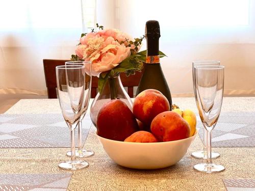 a table with a bowl of fruit and two wine glasses at Apartaments Platja d’Aro in Platja  d'Aro