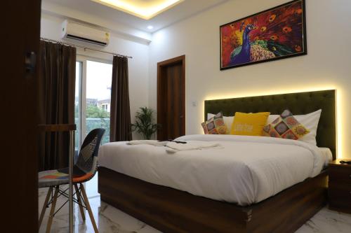 sypialnia z dużym łóżkiem z obrazem na ścianie w obiekcie Opulent Inn by Lime Tree Hotels w mieście Greater Noida