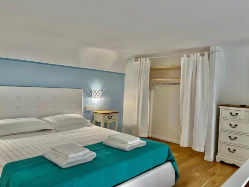 a bedroom with a white bed and a dresser at Il Bugi in Giovinazzo