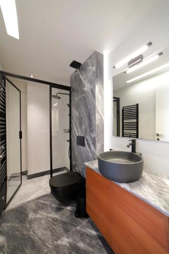 a bathroom with a sink and a toilet at Heraklion Harbour Penthouse in Heraklio