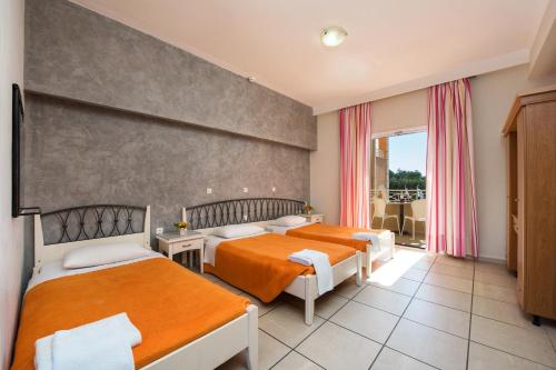 een hotelkamer met 2 bedden en een raam bij Kavos Plaza Hotel in Kavos