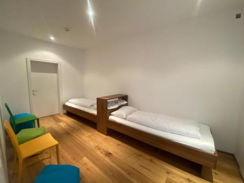 a room with two beds and a table and a chair at Schooren des Alpes Luxury Penthouses & Apartments with SPA & Pools close Ischgl in Kappl