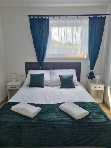 una camera da letto con un grande letto con tende blu di Apartamenty Jeleń Pod Grapom a Bańska Niżna
