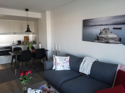 a living room with a blue couch and a kitchen at Lägenhetshotell Varvet in Ellös