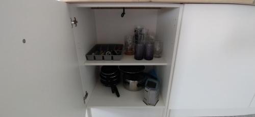 a cupboard with bottles and other items in it at Appartement pour 2 personnes in Annequin