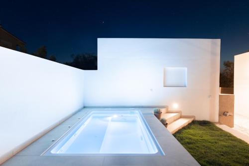 a swimming pool in the middle of a house at night at Van Loui's II Place in Áyioi