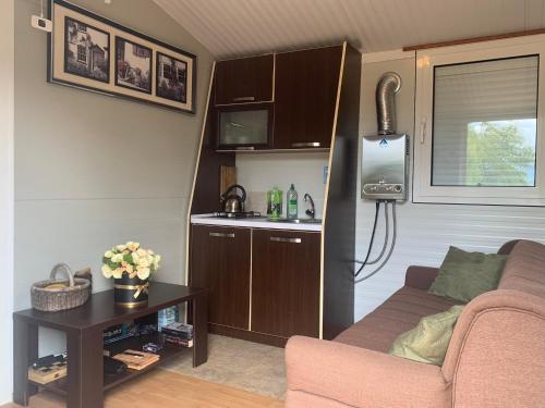 a living room with a couch and a kitchen in a caravan at Tiny house & Glamping tent in Kotor