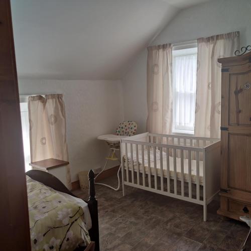 a baby bedroom with a crib and a window at Lovely 4-bed property in Mullaghbawn in Meigh
