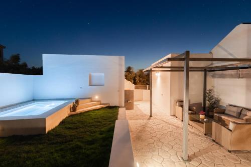 a backyard with a swimming pool at night at Van Loui's II Place in Áyioi
