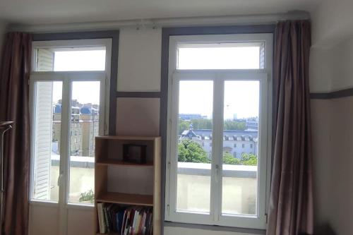 - deux fenêtres dans une chambre avec vue sur un bâtiment dans l'établissement Logement entier, vue, Paris centre, Catacombes, à Paris