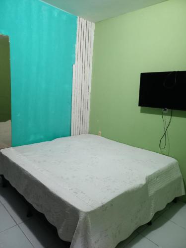 a bed in a room with a blue wall at Quarto dormitório in Campina Grande