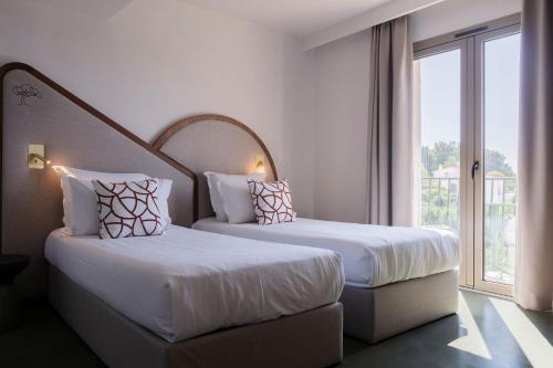 Katil atau katil-katil dalam bilik di Hôtel du Parc Cavalaire sur Mer