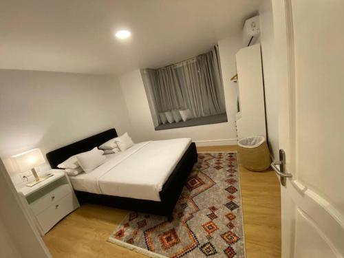 a small bedroom with a bed and a window at Apartment X Palm Village Mikocheni in Dar es Salaam