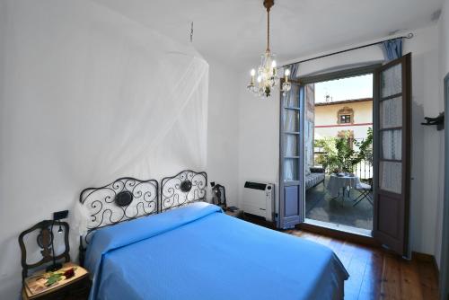 a bedroom with a blue bed and a large window at Il Drago al Roseto del Drago in San Bernardo