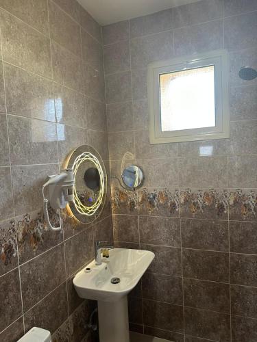 a bathroom with a sink and a mirror at ريف الشرق للشقق الفندقية in Al Madinah