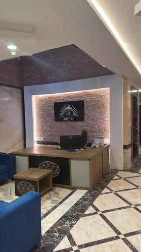 a lobby with a desk and a brick wall at ريف الشرق للشقق الفندقية in Al Madinah