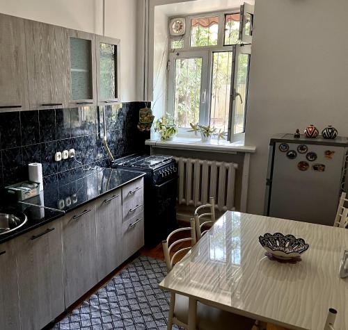 uma cozinha com uma mesa, um lavatório e um fogão em Humo Family Home em Tashkent