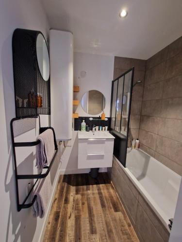 La salle de bains est pourvue d'une baignoire blanche, d'un lavabo et d'une baignoire. dans l'établissement Studio cœur des Sables, 100m de la plage, à Les Sables-dʼOlonne