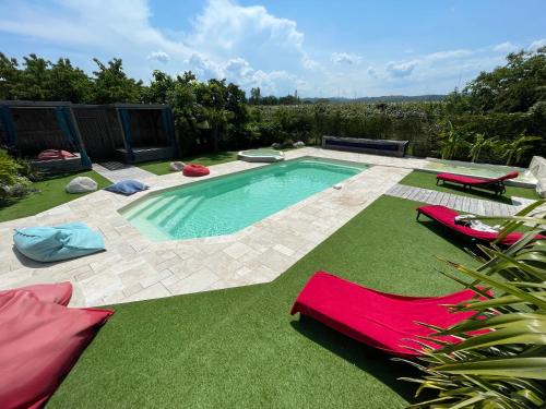 - une piscine avec 2 chaises longues et une piscine dans l'établissement Grande maison de charme avec piscine au coeur des vergers et vignobles, à La Roche-de-Glun