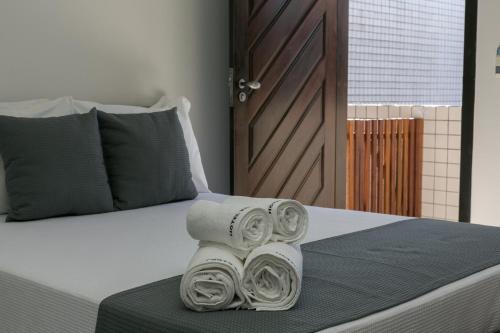 a bed with two rolls of towels on it at Hotel Pousada Porto da Lua in Guaratuba