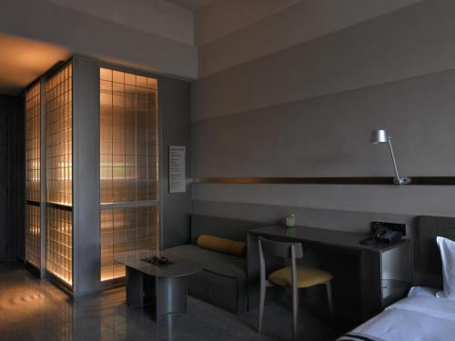 a hotel room with a bed and a desk and a table at NOA Hotel SHENZHEN LUOHU in Shenzhen