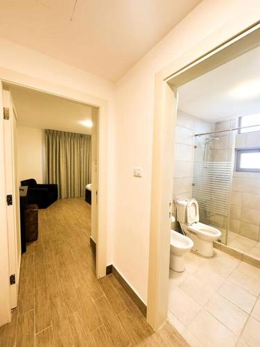 a bathroom with a toilet and a shower and a sink at central apartment for rent 26 in Umm Uthainah