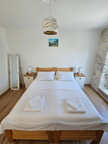 1 dormitorio con 1 cama blanca grande y 2 toallas en APARTMAN ELI, en Supetar